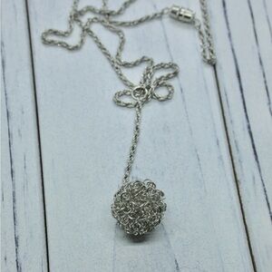 Drop pendant in knotted links on a silvertone necklace.